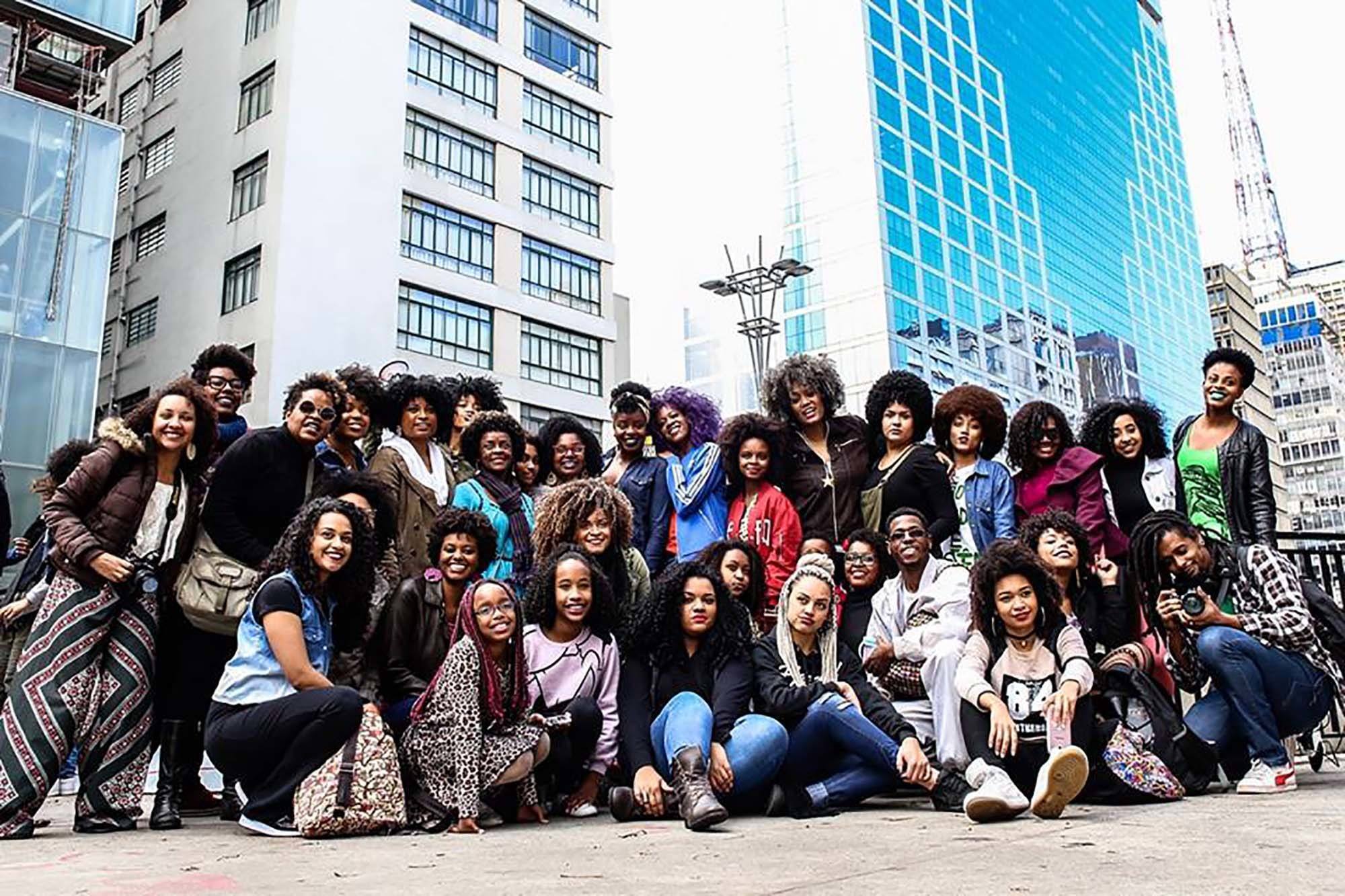 Mulheres e homens de cabelo crespo reunidos na marcha do orgulho crespo