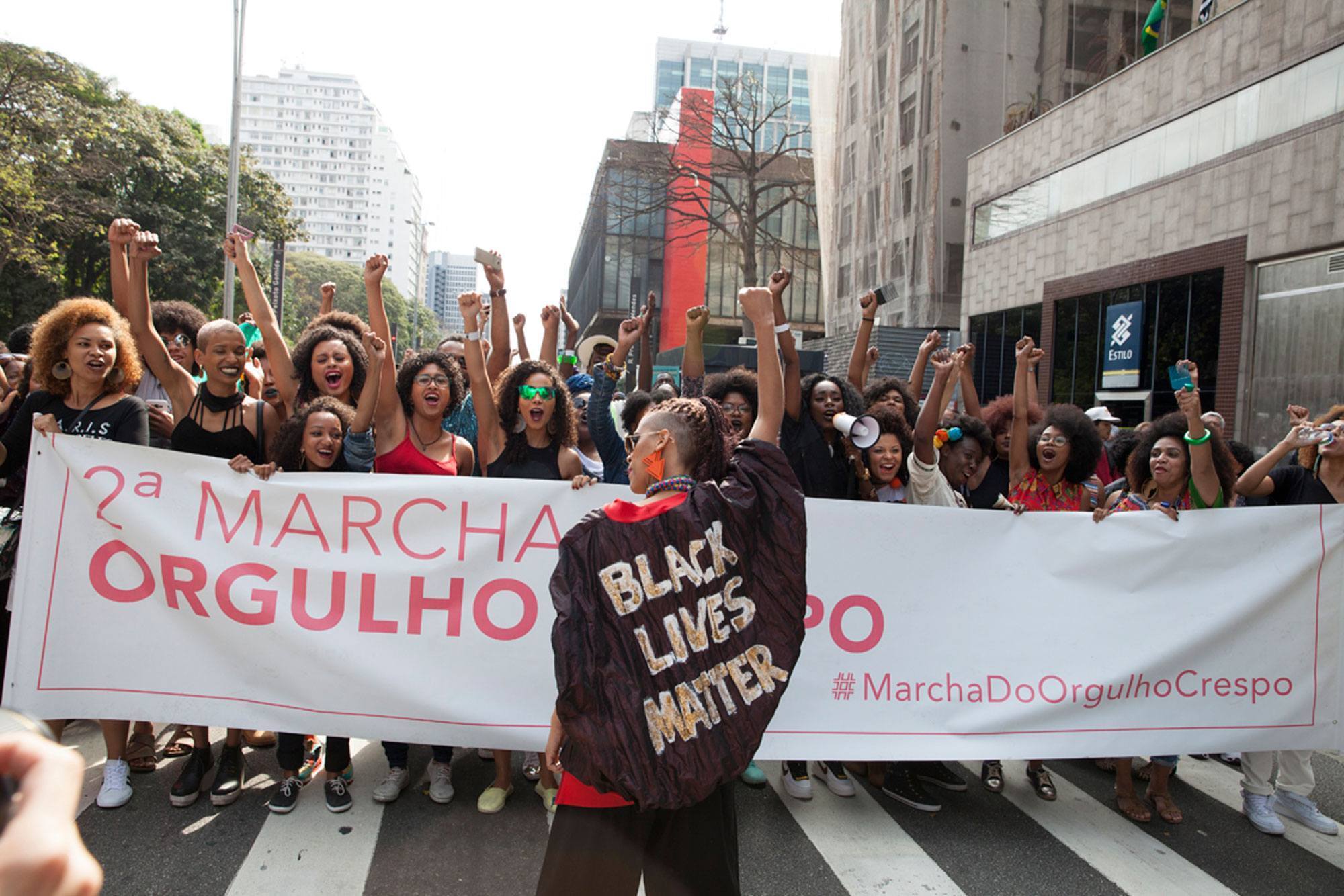 Mulheres e homens de cabelo crespo reunidos na marcha do orgulho crespo