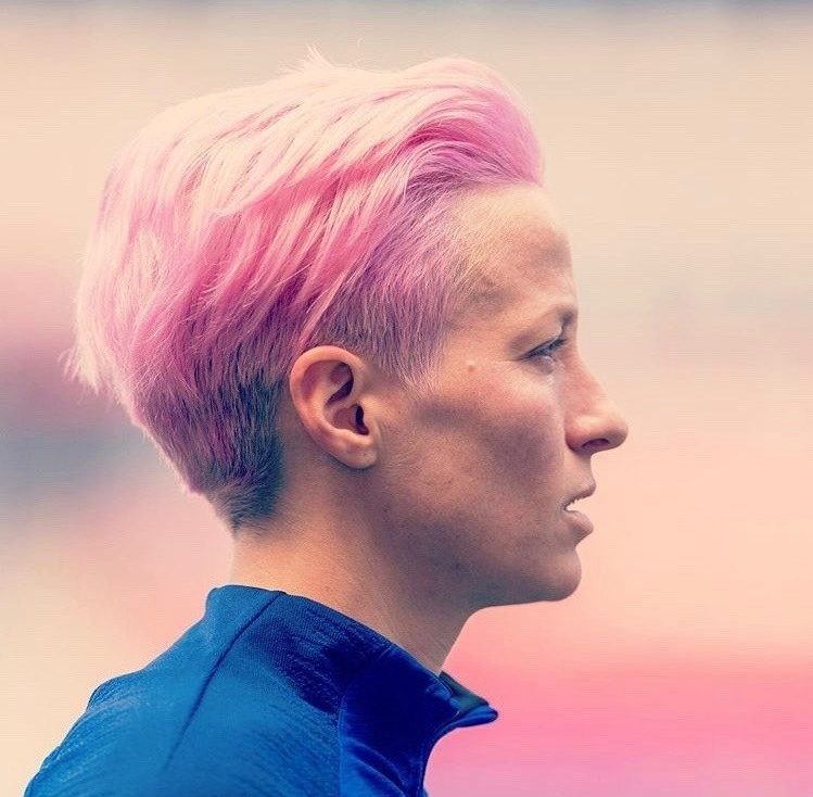 jogadora de futebol feminino Megan Rapione com cabelo curto pixie de cor rosa.