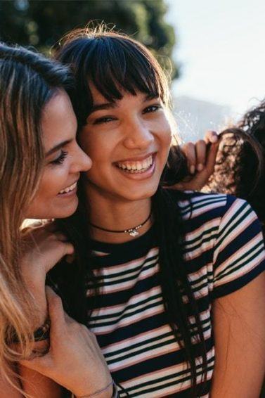 rês amigas rindo juntas
