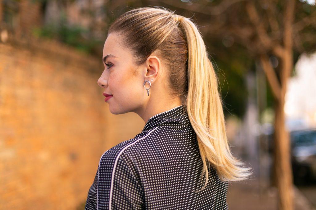 Modelo com cabelo loiro liso preso em um rabo de cavalo