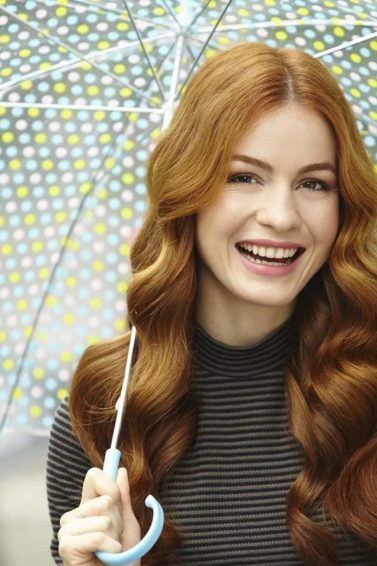 modelo de cabelo ruivo longo ondulado com um guarda-chuva