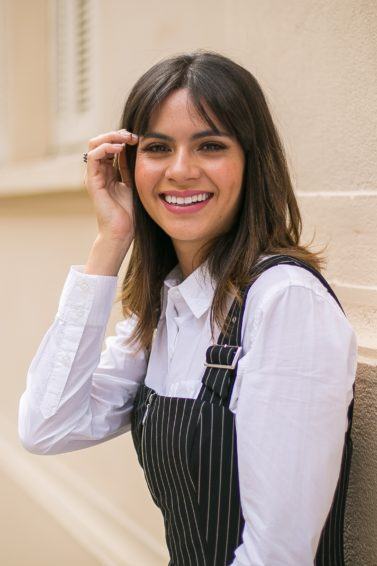 Modelo com cabelo curto castanho solto e franja dividida ao meio
