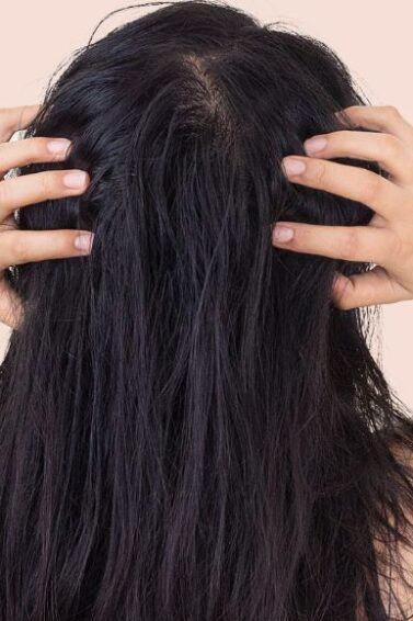 mulher de costas com as mãos na cabeça