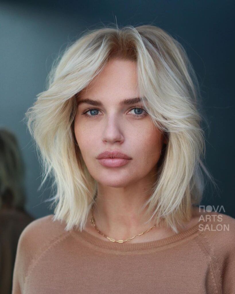 Mulher loira com corte de cabelo médio feminino em camadas com franja