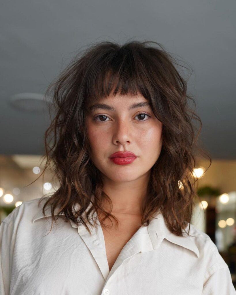 Mulher morena com corte de cabelo médio feminino