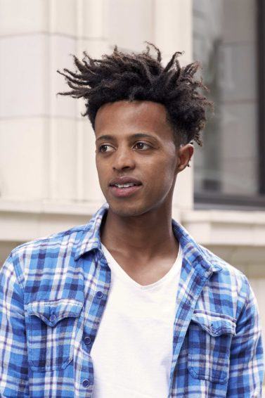 Homem com cabelo volumoso no topo para matéria de cortes afro curtos masculinos