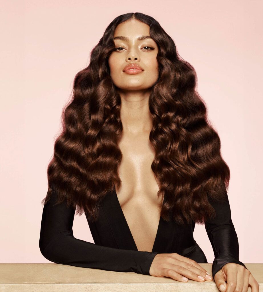 mulher com cabelo longo ondulado e blusa com decote