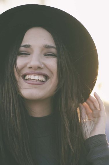 Mulher de chapéu feliz porque dá para descolorir cabelo preto, sim