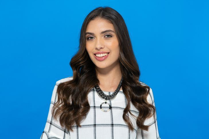 Modelo com cabelo castanho, longo e com ondas largas para alongar o rosto