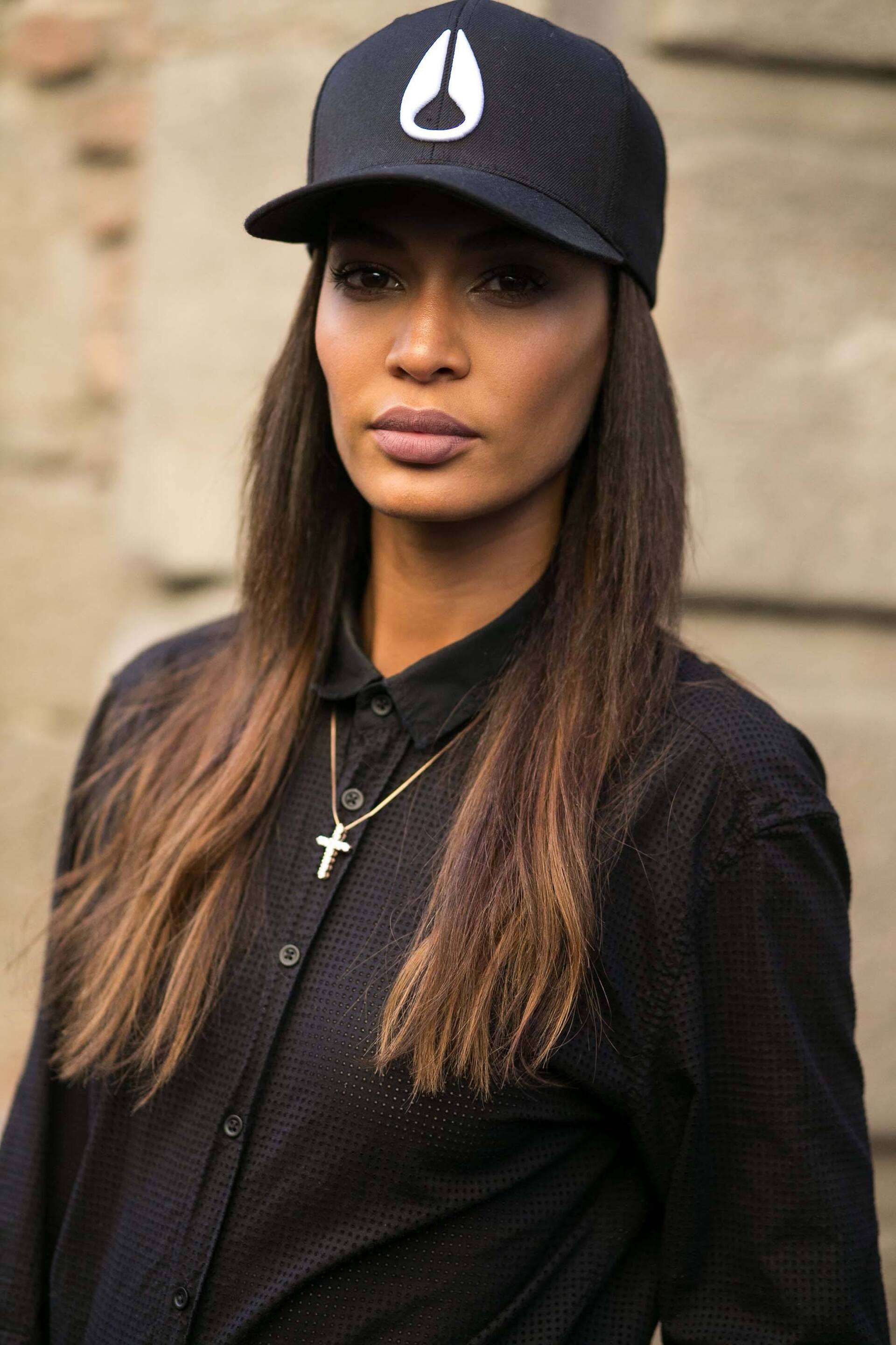 Modelo com cabelo liso e castanho usando boné em referência ao hip hop
