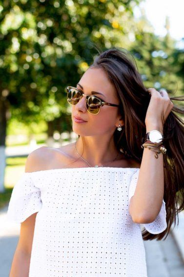 Simpatias para queda de cabelo: modelo com blusa branca mexendo no cabelo