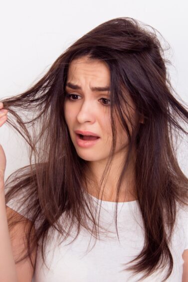 mulher segurando o cabelo preocupada