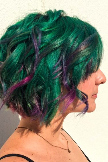 Mulher com cabelos verdes e mechas roxas
