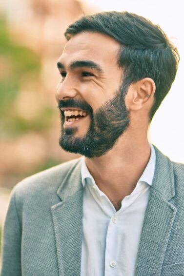 homem de terno de perfil sorrindo