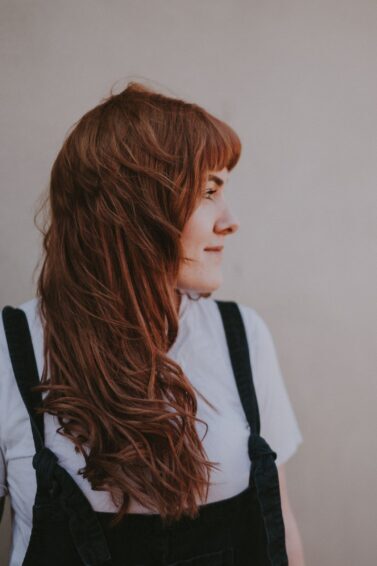 mulher de lado com cabelo ruivo com franja