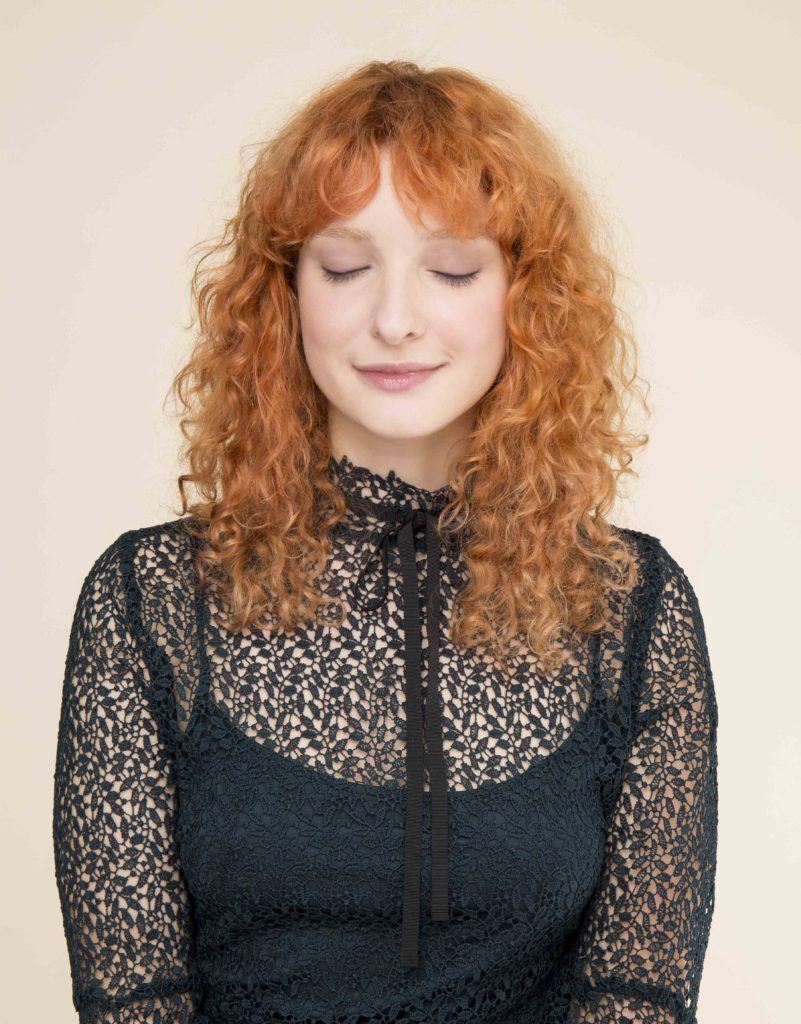 modelo de cabelo ruivo natural cacheado e com franja