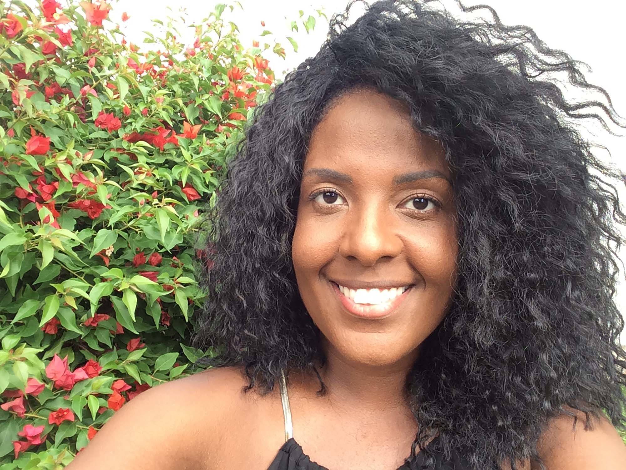 Monique dos Anjos tem o cabelo preto e cacheado