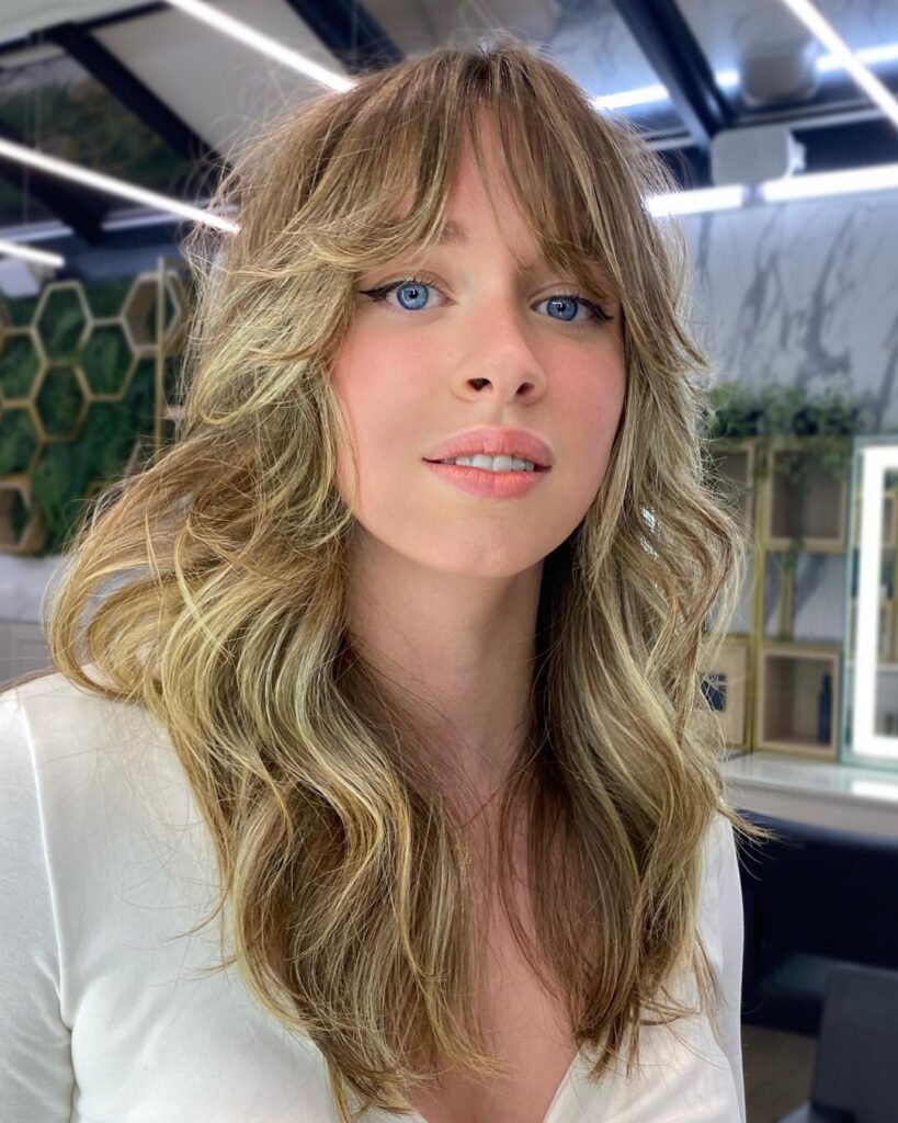 Mulher loira no salão com mullet feminino estilo shaggy hair em camadas no cabelo loiro com luzes