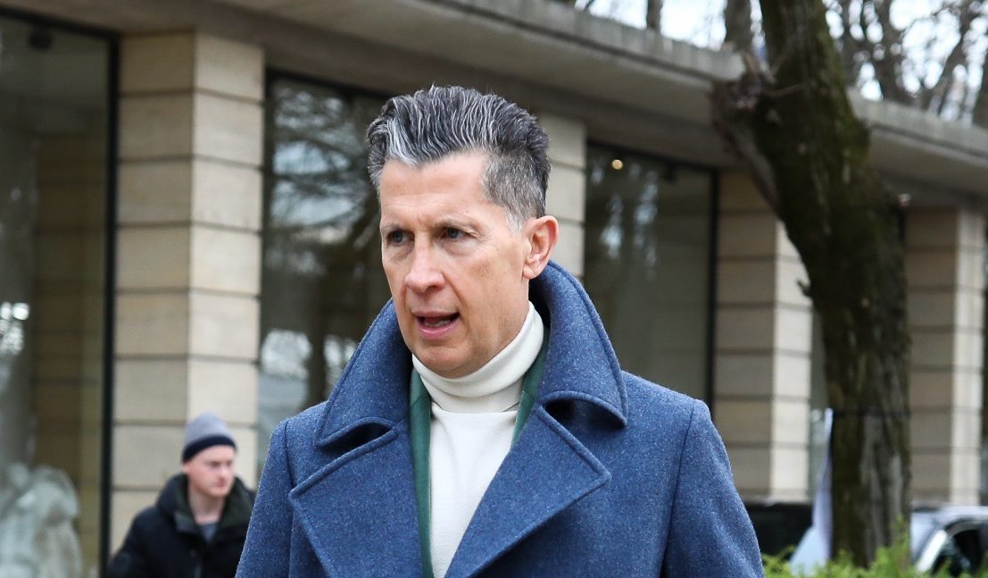 Homem usa topete e veste casaco azul