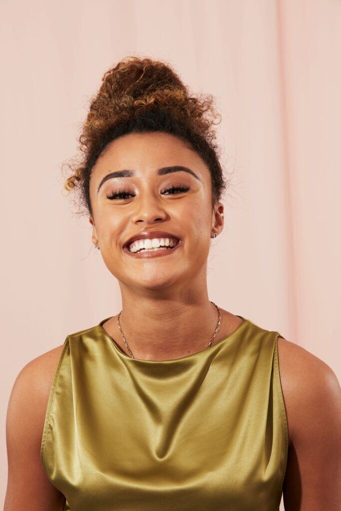 mulher sorrindo com coque alto cacheado