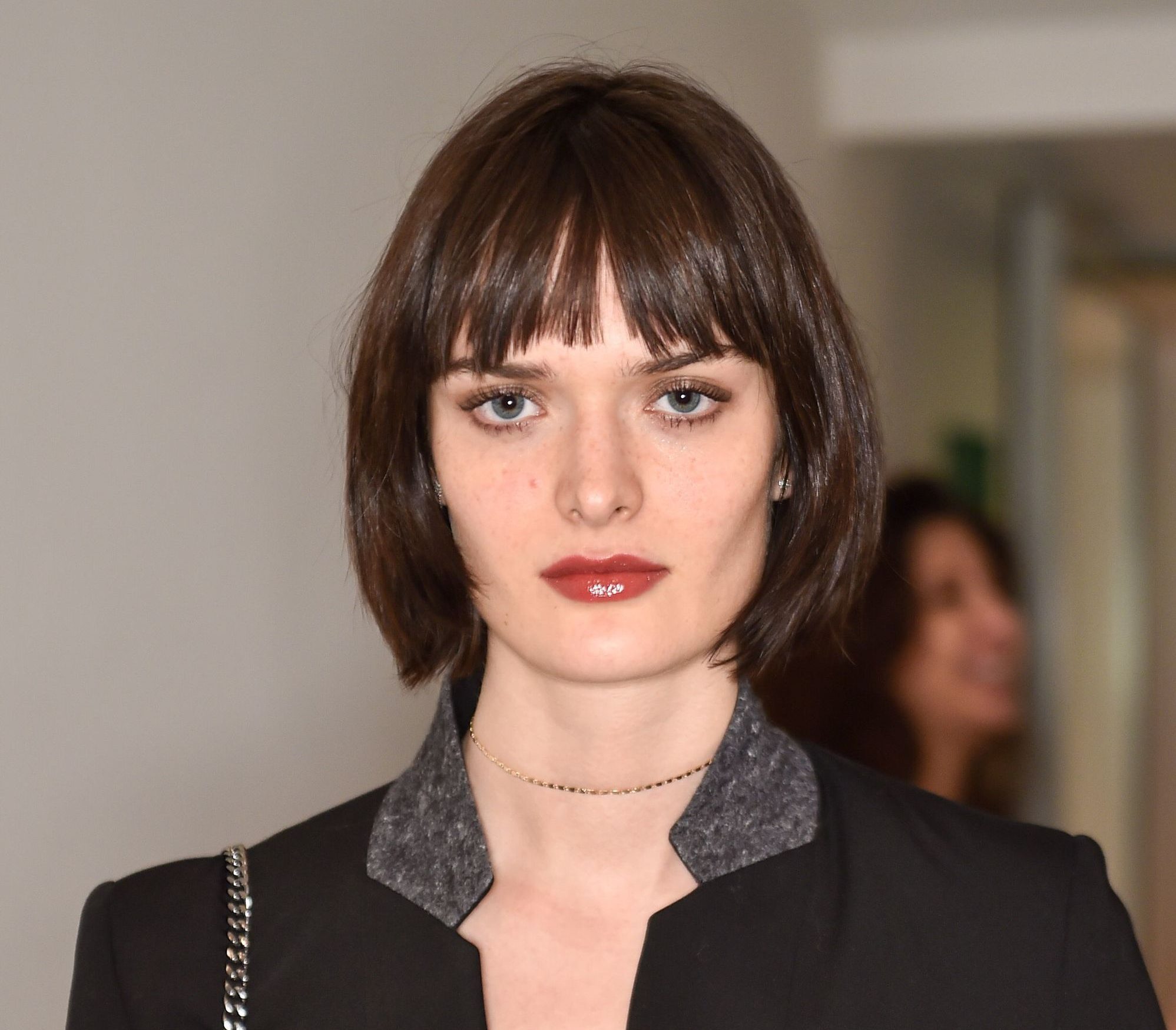 Modelo Isabeli Fontana posa em evento de moda com blazer preto e cabelo chanel castanho escuro