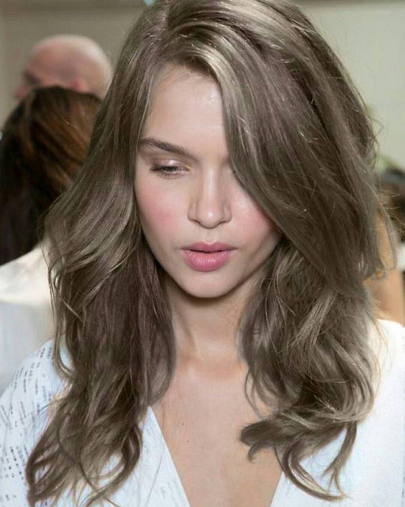 Mulher com cabelo loiro escuro acinzentado