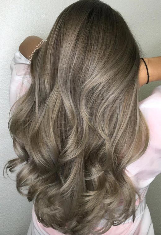 Foto com mulher com cabelo loiro escuro acinzentado visto de trás