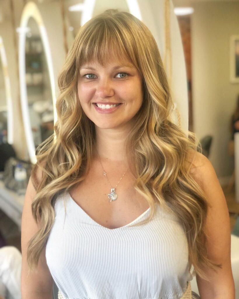 Mulher com cabelo loiro longo com franja