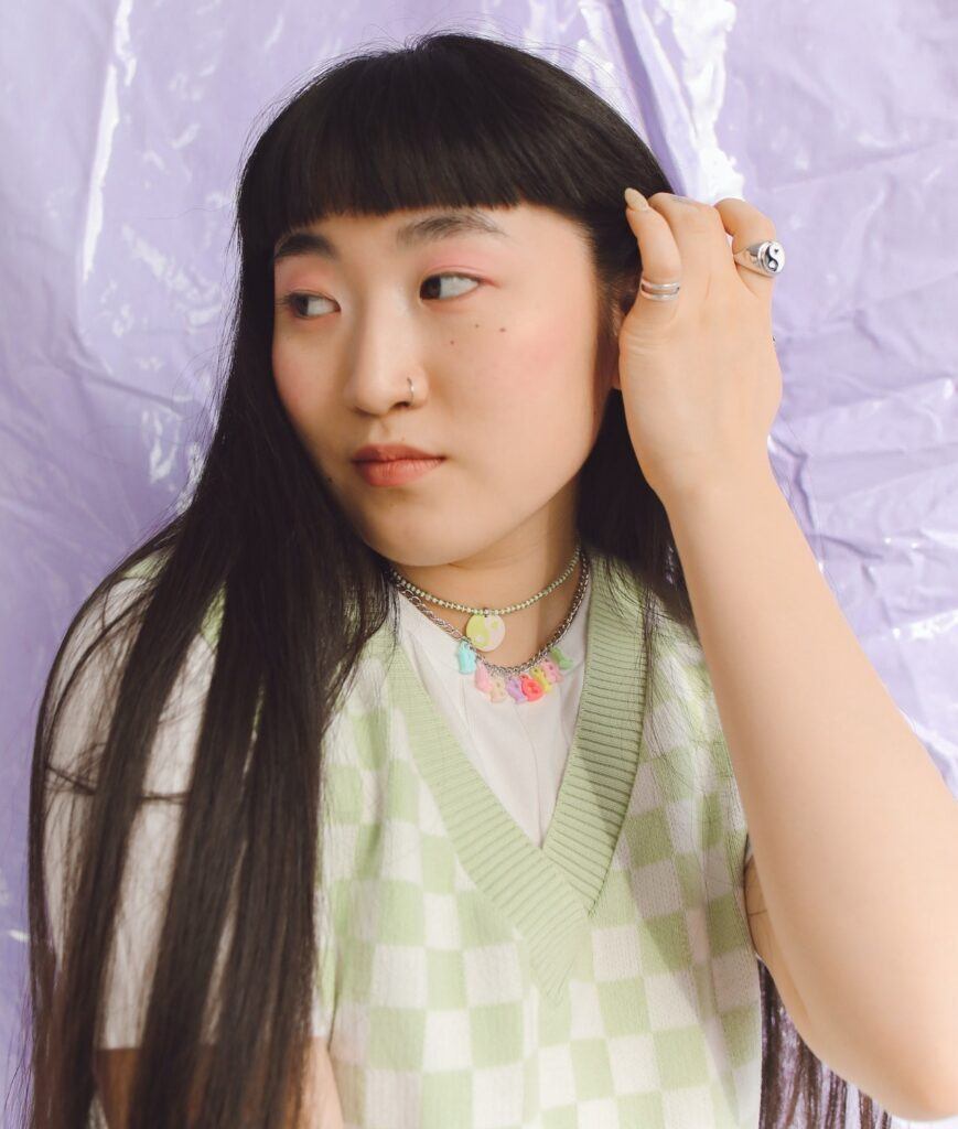 Mulher posa com cabelo preto liso com franja curtinha baby bangs vintage