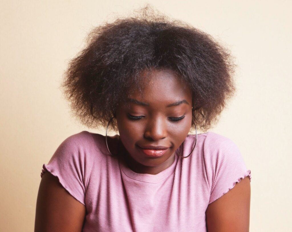 Mulher de cabelo curto big chop crespo em transição capilar