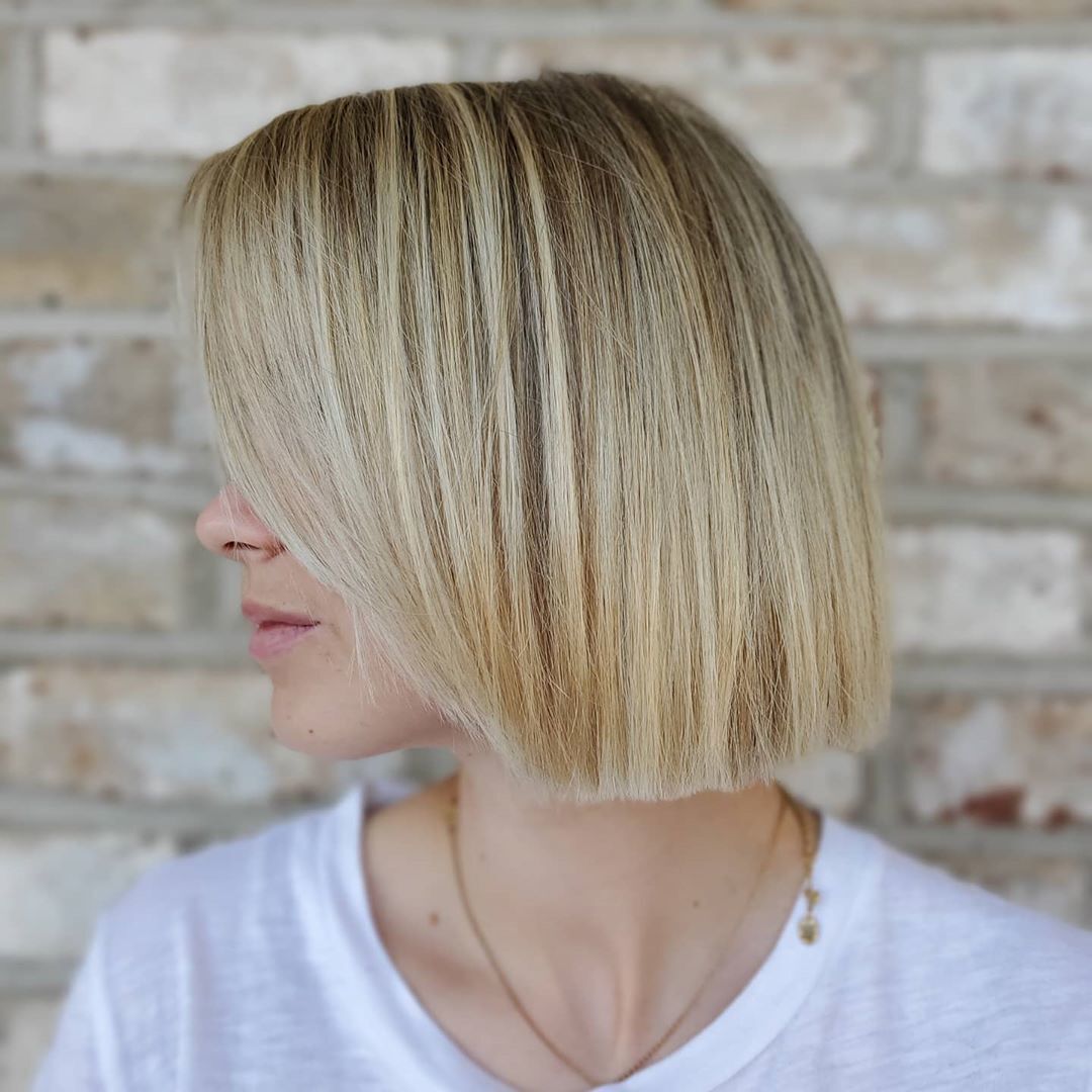 Mulher com cabelos loiros e lisos e corte reto, o famoso blunt cut