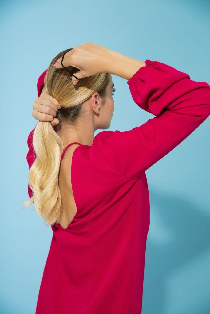 Cabelo liso loiro sendo amarrado