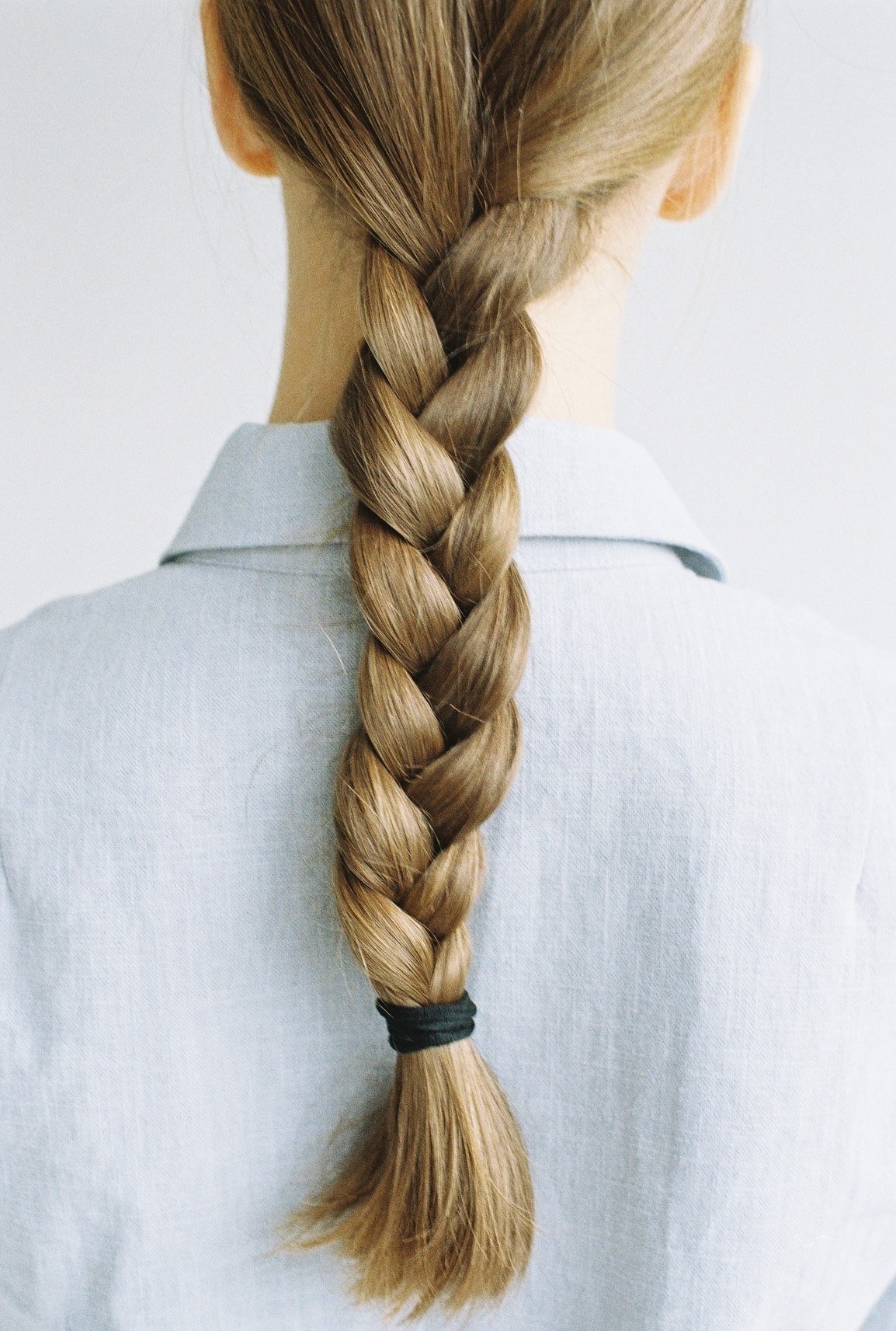 Mulher de costas destaca traça simples feita no cabelo loiro