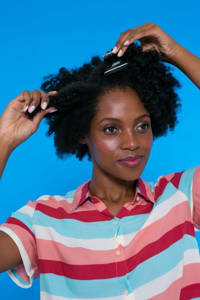 modelo de cabelo afro prendendo os fios para pentear