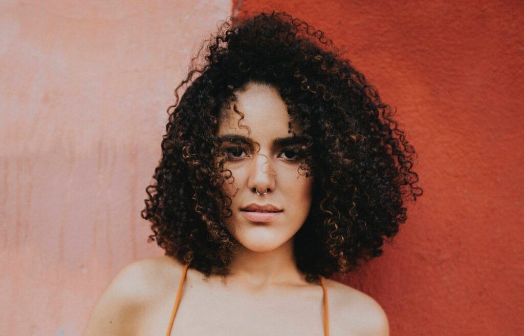Mulher de cabelo cacheado após usar queratina