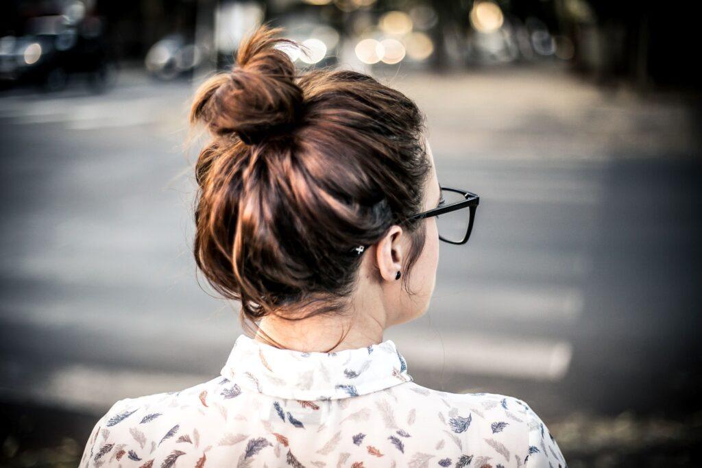mulher com cabelo castanho e coque bagunçado