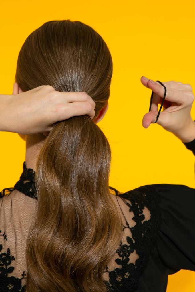  cabelo liso sendo preso com rabo de cavalo baixo
