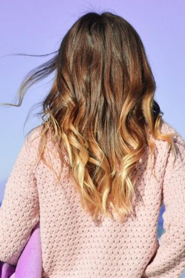 mulher com cabelo com corte em v ondulado longo