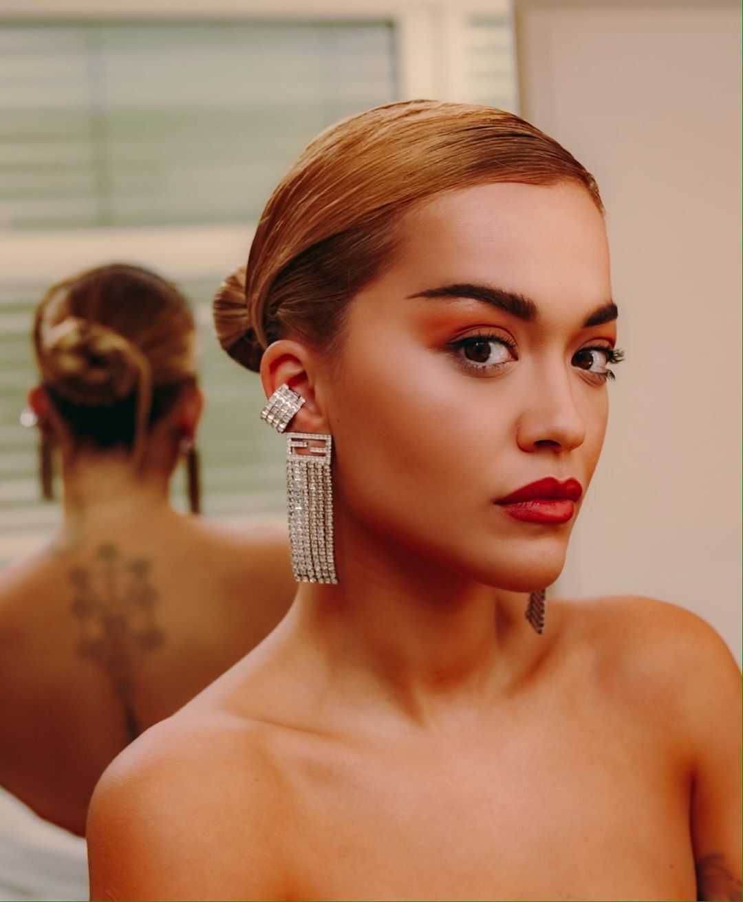 Rita Ora com cabelos loiros presos num coque