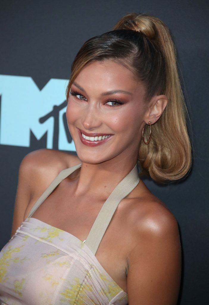 modelo bella hadid com rabo de cavalo alto com franja lateral loiro