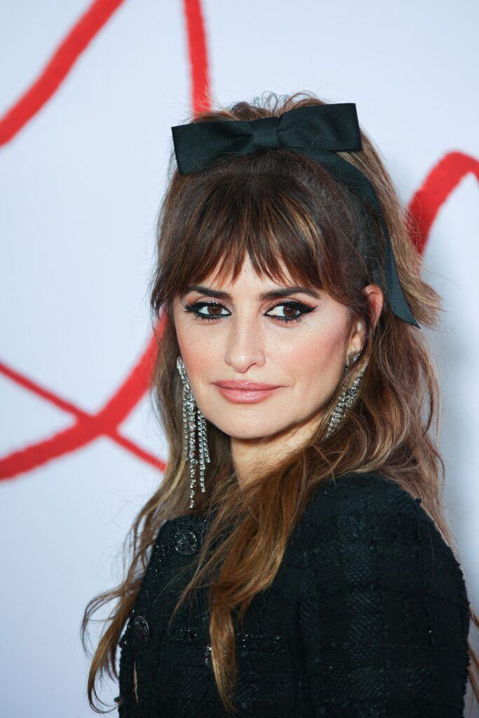 atriz penélope cruz com cabelo semipreso com laço preto