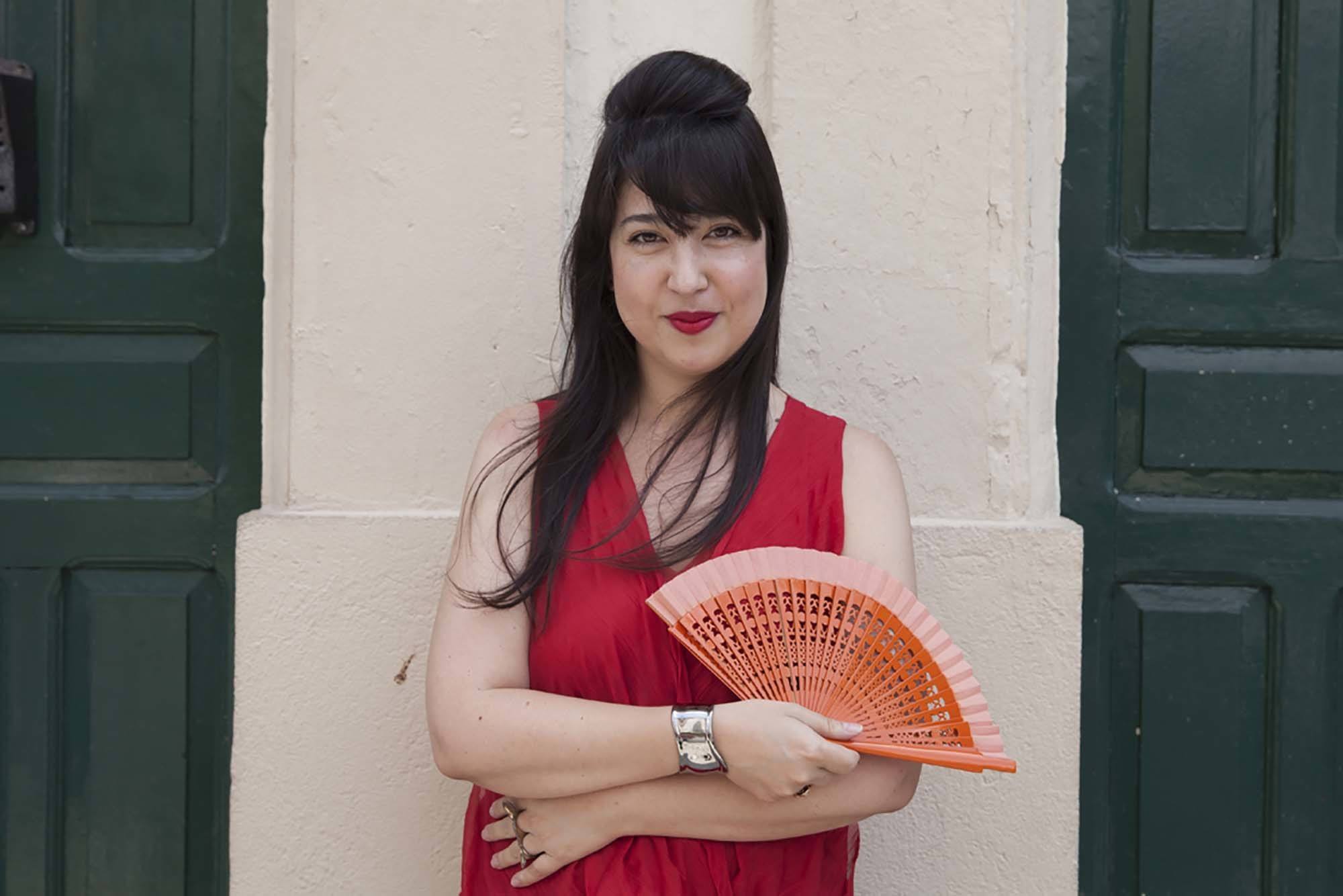 Mulher oriental usa vestido vermelho, leque e topete com franja, um dos tipos de topete