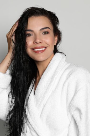 mulher com cabelo úmido de roupão branco