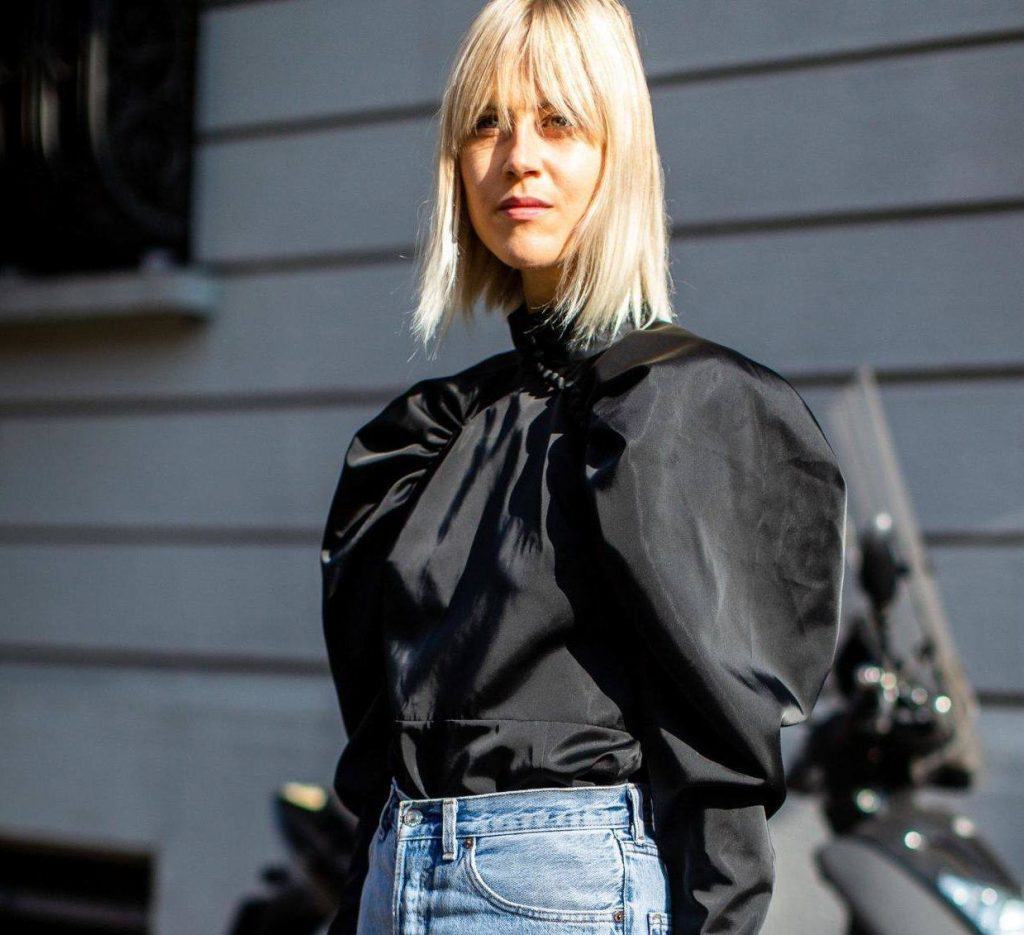 Mulher com cabelo médio, loiro e com franja comprida