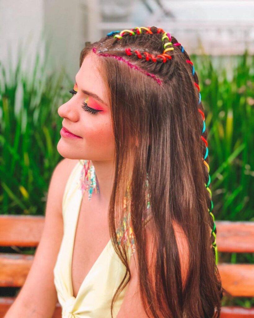 Mulher morena de trança raiz com fita de seda colorida
