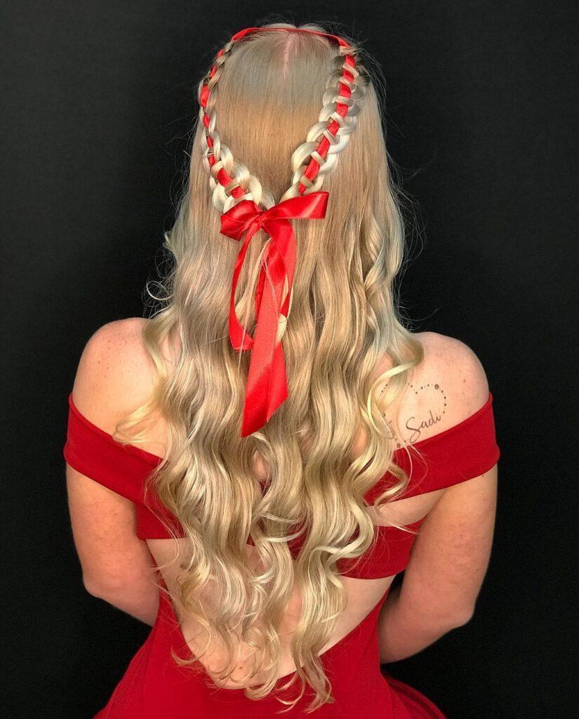 Mulher posa de vermelho com penteado semipreso de trança com fita de cetim