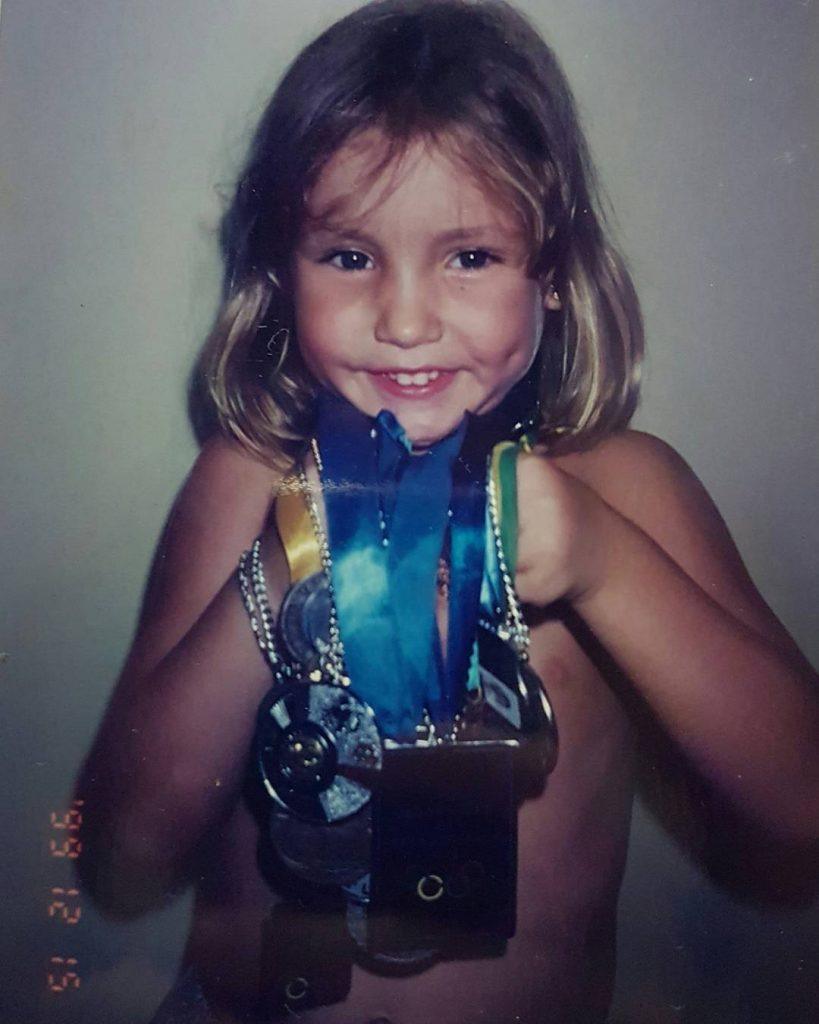 duda miccuci segurando medalhas quando era criança