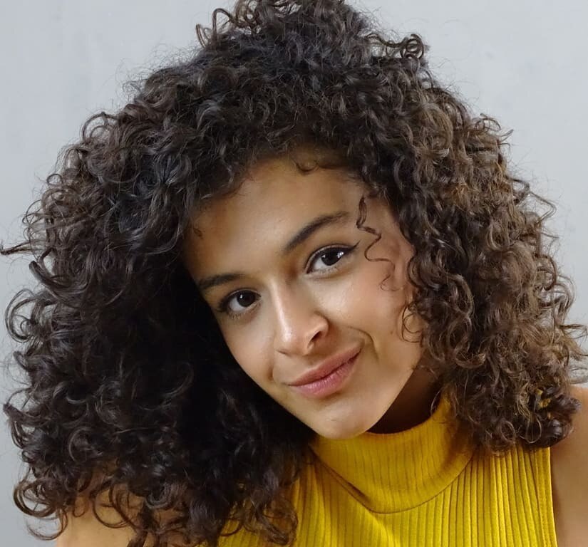 Mulher com cabelos cacheados e castanhos com desprogressiva