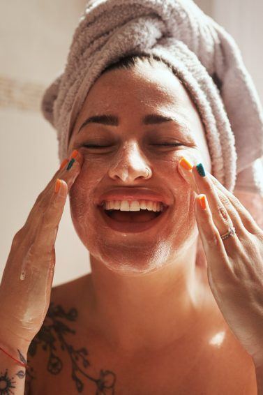 mulher sorrindo com toalha na cabeça